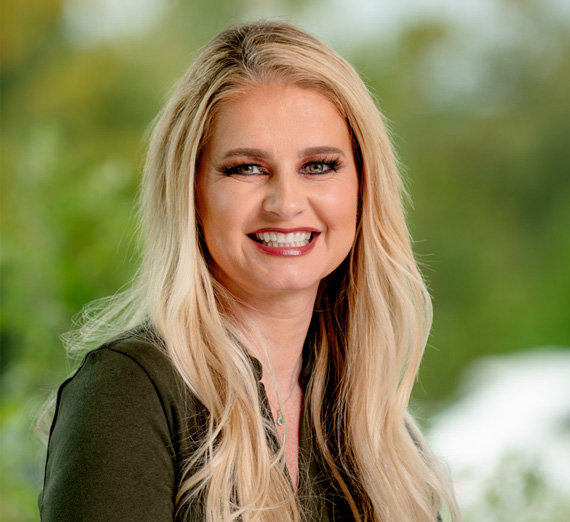 明るく照らされた病院の廊下に五人のグループが立ち、カメラに向かって笑っている。二人はステトスコープと医療用衣装を着ており、一人はゴンザガ大学のスウェットシャツを着ており、他の人々はカジュアルまたはプロフェッショナルな服装で、学生と医療専門家が混在している様子を表している